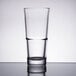 A close-up of a Libbey stackable cooler glass filled with water on a table.