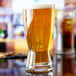 An Anchor Hocking Bavarian Pilsner glass of beer on a table.