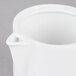 An Arcoroc white porcelain teapot with a lid and handle.