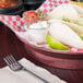 A plate of tacos and salsa served in a raspberry round deli server.