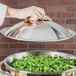 A hand using a Vollrath Panacea chafer lid to serve green beans.