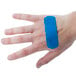 A person wearing a blue Medique adhesive strip bandage on their hand.