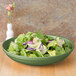 A CAC Festiware green bowl filled with salad, lettuce, and purple cabbage.