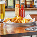A Tablecraft galvanized steel platter of fried food on a table in a family-style restaurant.