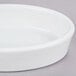 A white Hall China oval baker dish on a gray surface.