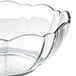 An Arcoroc clear glass bowl with a scalloped edge.