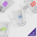 A group of clear SAN plastic shot glasses with a blue logo.