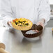 A chef preparing a tart in a Gobel fluted tart pan.