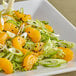 A plate of salad with whole mandarin orange segments.