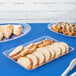 A clear plastic rectangular tray with sliced bread on a table.