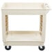 A beige plastic utility cart with two shelves and black wheels.