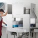 A commercial double rack low temperature dishwasher with stainless steel construction, shown in use with dish racks inside.