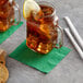 A glass mug with a Choice Green beverage napkin and a lemon slice on the rim.