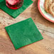 A plate of cookies with a green Choice Green beverage napkin on a table.