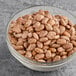 A bowl of dried pinto beans on a table.