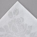 A white Hoffmaster dinner napkin with a rose design.