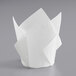 A white paper tulip baking cup with folded paper on top.