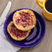 A cobalt blue Tuxton Concentrix China plate with muffins and jam on it.