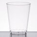 A Fineline Savvi Serve clear plastic tumbler on a white surface.