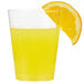 a slice of orange next to a glass of juice