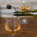 A bottle of wine being poured through a black Franmara wine filter/pourer into a glass of wine.