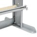 A gray metal shelf with a wooden bar.
