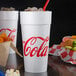 A Dart white foam cup with red Coca-Cola text.