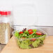 A salad in a Genpak clear plastic deli container with a high dome lid.