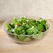 A Cambro pebbled serving bowl filled with salad on a table.