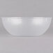 A clear plastic bowl with a white rim on a white surface.