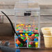 A Cal-Mil stackable topping dispenser with candy in it on a counter.