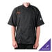 A man wearing a Mercer Culinary black chef coat with short sleeves.