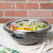 A clear Fineline flat plastic lid on a salad bowl filled with salad.