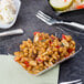 A clear Fineline rectangular tray filled with beans and vegetables on a table.