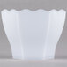 A white hexagon bowl with wavy edges on a gray surface.