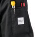The pocket on a Mercer Culinary Genesis chef jacket with a pen and pencil in it.