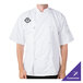 A man wearing a white Mercer Culinary chef jacket with a black logo.