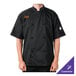 A man wearing a black Mercer Culinary chef coat with orange embroidery.