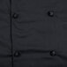 A close up of a black Mercer Culinary chef jacket with cloth knot buttons.