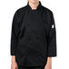 A young woman wearing a Mercer Culinary black chef coat.