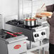 A stainless steel Garland GTOG12-2 natural gas 2 burner 12-inch countertop range in use in a commercial kitchen.