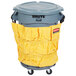 A grey Rubbermaid BRUTE trash can with a yellow bag on a dolly.