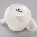 An eggshell white china teapot with a black handle.