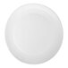 A large, round, white stoneware charger plate with a matte finish.