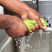 A person washing a Cordova Cooling Towel in a sink.