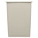 A beige plastic half round Rubbermaid Untouchable trash can.