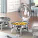 An Acopa Voyage chafer stand with food on a table outdoors.