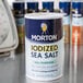 A close-up of a black and white Morton 26 oz. All-Purpose Iodized Sea Salt container.