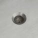 A silver screw hole in a metal surface.