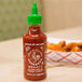 A case of 24 Huy Fong Sriracha Hot Chili Sauce bottles on a table.